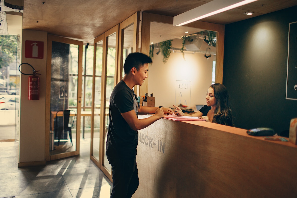 A guest talking to a receptionist while checking in at a hotel. 