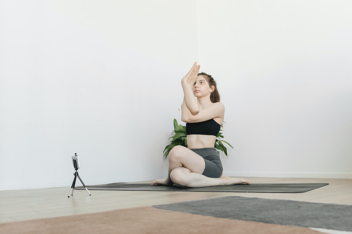 A women teaching a live online yoga class. 