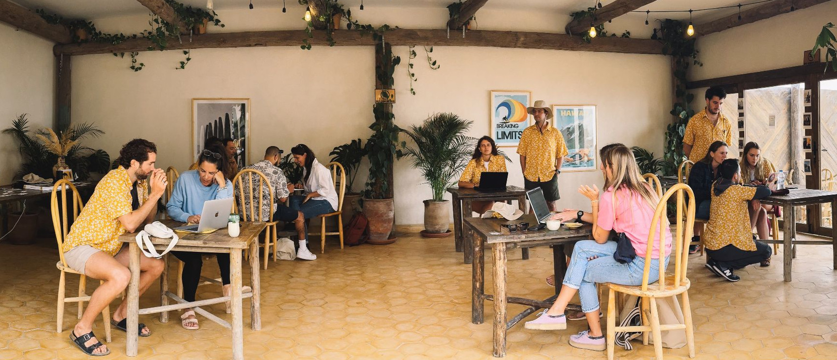 People at a cafe sitting at various tables collaborating.